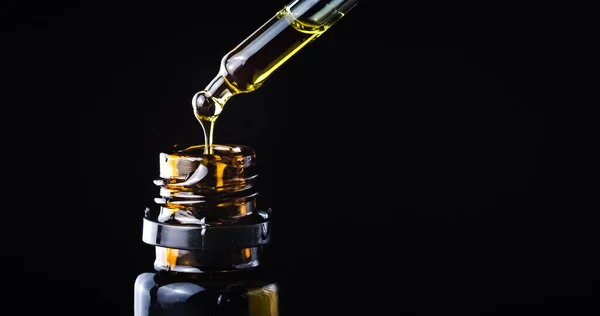 CBD hemp oil in a droplet on black — Stock Photo, Image