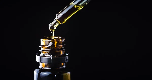 CBD hemp oil in a droplet on black