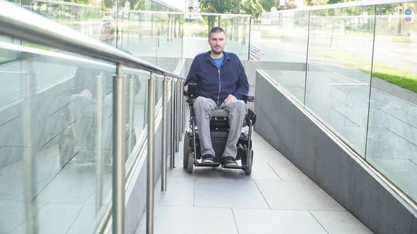 Vooraanzicht van een man in een elektrische rolstoel die op straat rijdt. Toegankelijkheidsconcept — Stockfoto