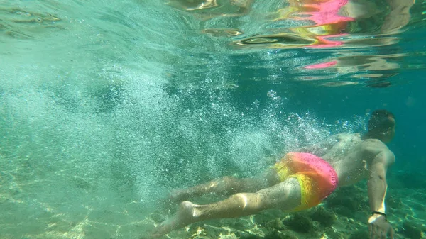 Jonge student fit mannelijke sprong in het water en is het hebben van plezier in de zomer — Stockfoto
