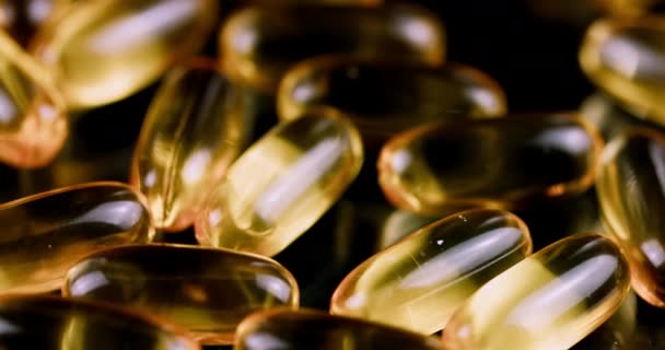 Fish oil capsules on black background — Stock Video