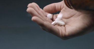 Holding many white drug pills