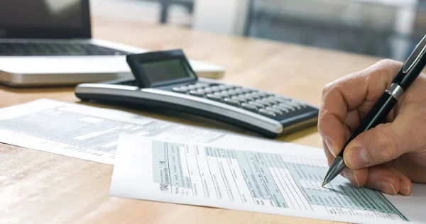 Businessman filling 1040 tax form — Zdjęcie stockowe