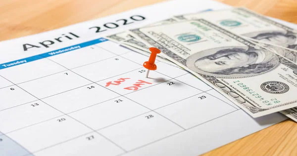 Dollars on calendar marked for tax day — Stockfoto