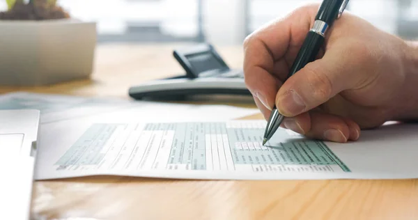 Persona que llena el formulario de impuestos — Foto de Stock