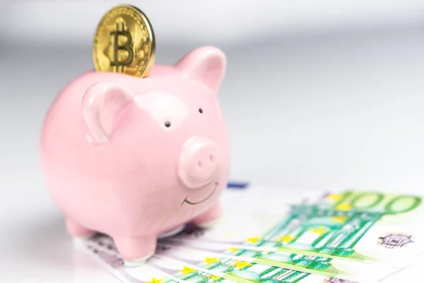 Bitcoin em banco porquinho ao lado de notas de euro — Fotografia de Stock