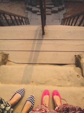 Otelin terasında sandalet giymiş kadın bacakları.