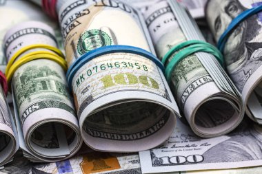 100 dolarlık banknotlar arka planda.