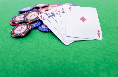 Beş poker kartı yeşil bir masada bir yığın fiş üzerinde kazanan bir oyun.