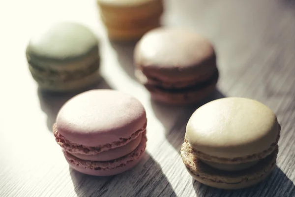 Macaroons illuminated by sun rays casting their shadow — Stock Photo, Image