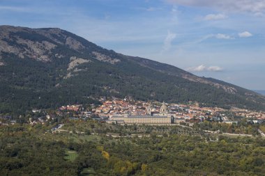 San Lorenzo del Escorial kasabası ve Madrid 'de bulunan ve Sierra de Guadarrama' nın doğal çevresiyle çevrili ünlü manastır manzarası.