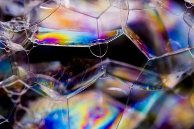 Çeşitli sabun baloncuklarının makro fotoğrafçılığı çarpıcı renklerle farklı geometrik şekiller yaratıyor, seçici odaklanma