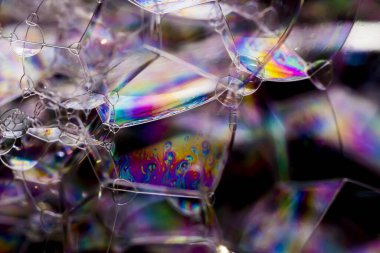 Çeşitli sabun baloncuklarının makro fotoğrafçılığı çarpıcı renklerle farklı geometrik şekiller yaratıyor, seçici odaklanma
