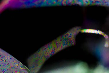 Bir sabun köpüğü tarafından oluşturulan çarpıcı renklerin makro fotoğrafçılığı, seçici odak