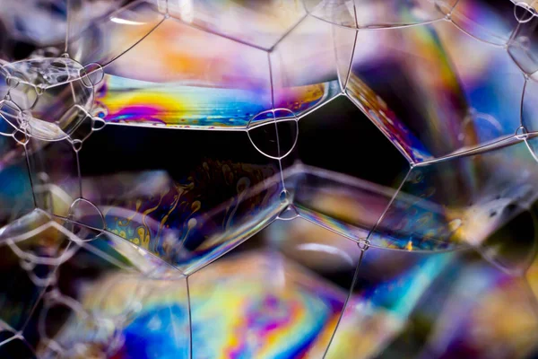 Macro photography of various soap bubbles creating different geometric shapes with striking colors, selective focus