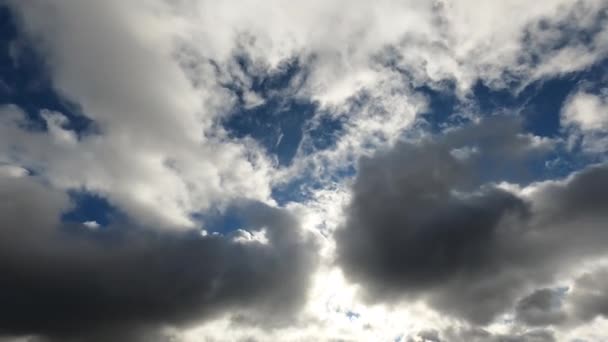 Time Lapse 4k, de nuages gris traversant rapidement le ciel bleu et couvrant le soleil 