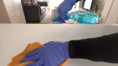 Ellerinde nitril eldiven olan bir adamın elleri, masadaki temizlik ürününü kullanarak, virüslere ve diğer bulaşıcı hastalıklara karşı önlem ve önlem olarak, covid19, coronavirus, konsept, 4k