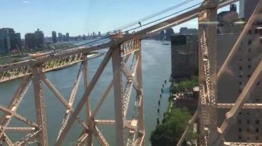 Manhattan 'ı Roosvelt Adası' na bağlayan teleferiğin içinden Queensboro Köprüsü 'nün yanından yükselişe geçen turistler, HD