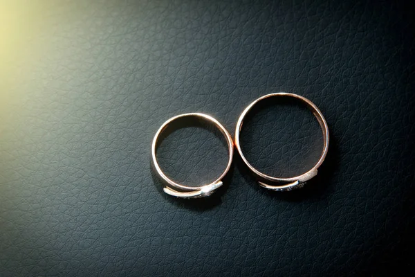 Dua Cincin Pernikahan Dengan Latar Belakang Kulit Hitam — Stok Foto