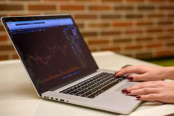 Dizüstü bilgisayar izlerken bitcoin grafikler ve hisse senetleri ile kız