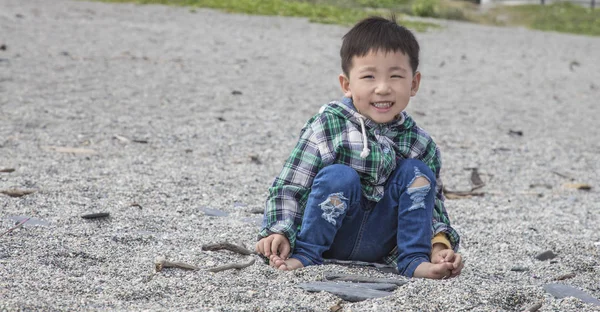 Bir Kumla Oynayan Bir Plajda Oturmuş Çocuk — Stok fotoğraf