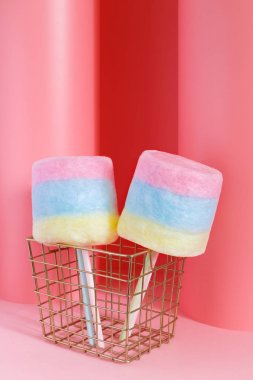 Bir sopa üzerinde pastel pembe bir arka plan üzerinde renkli pamuk şeker. En az kavramı.