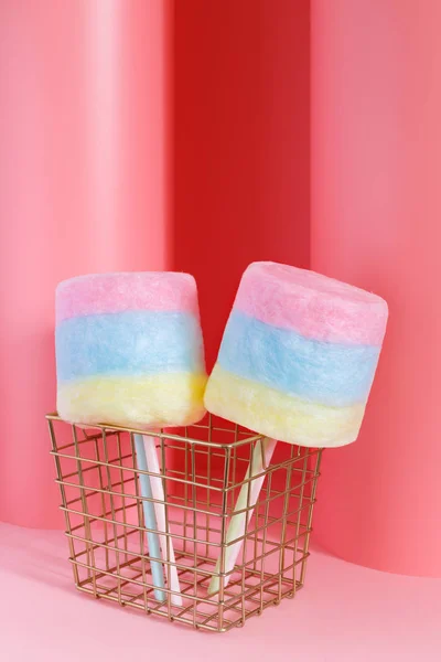 Colorido algodón de azúcar en un palo sobre un fondo de pastel rosa. Concepto mínimo . —  Fotos de Stock