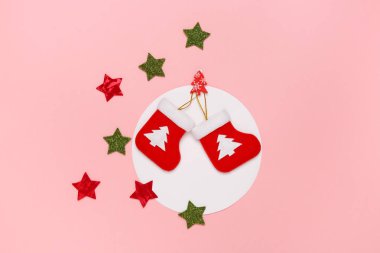 En az Noel kavramı. Pastel pembe arka plan üzerinde Noel çorap ve parlayan yıldız Üstten Görünüm. 