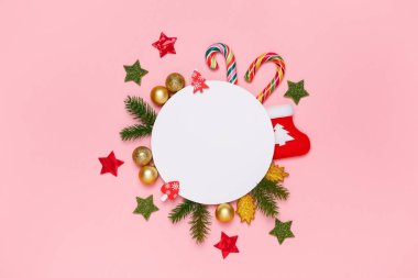 Noel mockup. Üstten Görünüm xmas süslemeleri, tatlılar, şeker kamışı, çam dalları, pastel pembe arka plan üzerinde. En az parlak stil. Yeni yıl kavramı.