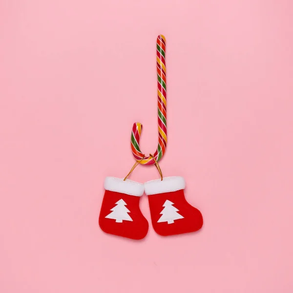 キャンディの杖とクリスマスの平面図は、パステル ピンクの背景のソックスします。最小限のクリスマス コンセプト. — ストック写真