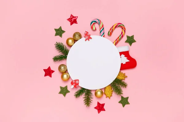 Um mockup de Natal. Vista superior de decorações de xmas, doces, cana-de-açúcar, ramos de abeto, em um fundo rosa pastel. Estilo minimamente brilhante. Conceito de Ano Novo . — Fotografia de Stock