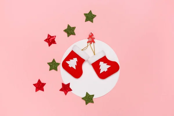 Concepto mínimo de Navidad. Vista superior de los calcetines de Navidad y estrellas centelleantes sobre un fondo rosa pastel . Imagen De Stock