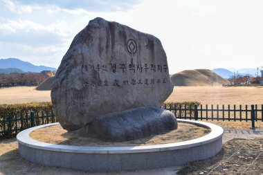 Güney Kore Gyeongju 'daki Daerungwon Kraliyet Mezarları Kompleksi' nin önündeki Stone UNESCO tabelası.