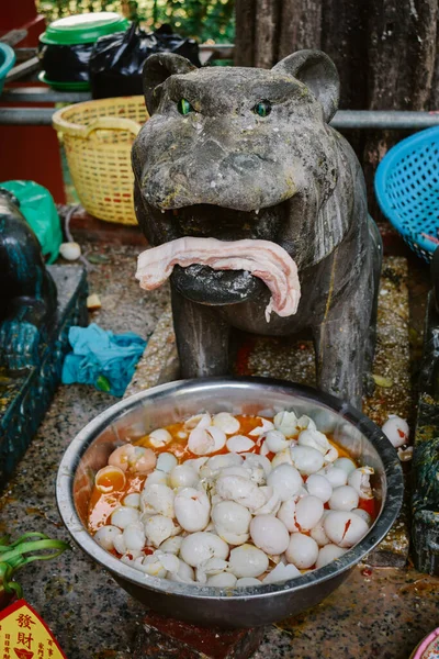 柬埔寨金边的瓦特金边寺 一只老虎的塑像上有火腿和鸡蛋作为祭祀用的礼物 — 图库照片