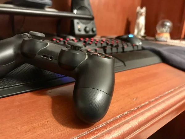 Puebla, Mexico; September 15 2019: Black gaming controller over a wooden desk with a mechanical keyboard — Stock Photo, Image