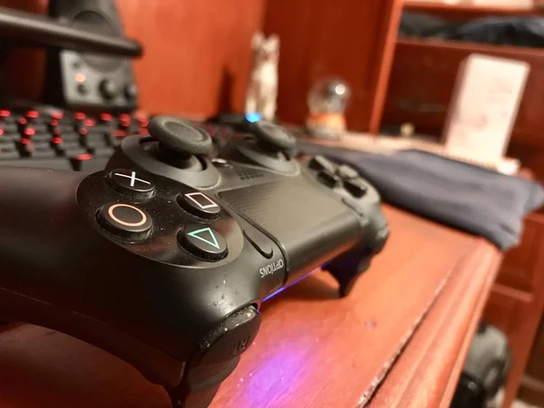 Puebla, Mexico; September 15 2019: Black gaming controller over a wooden desk with a mechanical keyboard — Stock Photo, Image