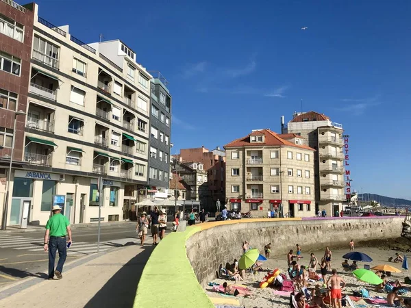 Sanxenxo, Pontevedra / Espanha - 26 de julho de 2018: Vista da praia de Sanxenxo com algumas pessoas andando no calçadão perto da praia de Silgar durante um dia de verão — Fotografia de Stock