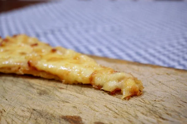 Tahta kesme tahtasının üstünde bir dilim peynir ve ananaslı pizza. — Stok fotoğraf