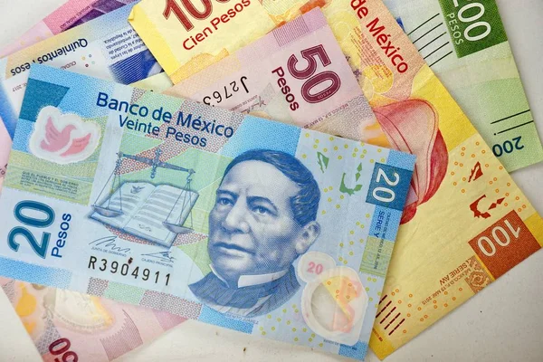 Billetes de pesos mexicanos distribuidos aleatoriamente sobre una superficie plana — Foto de Stock