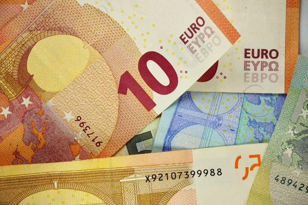 Muitas notas de euro diferentes distribuídas aleatoriamente por uma superfície Imagem De Stock
