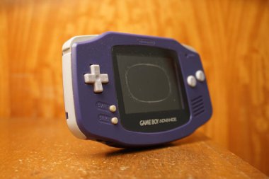 Puebla, Puebla / Meksika - 25 Aralık 2019: Yıpranmış bir Nintendo Game Boy Advance 'ın ahşap bir yüzey üzerindeki hasarlı ekranlı görüntüsü