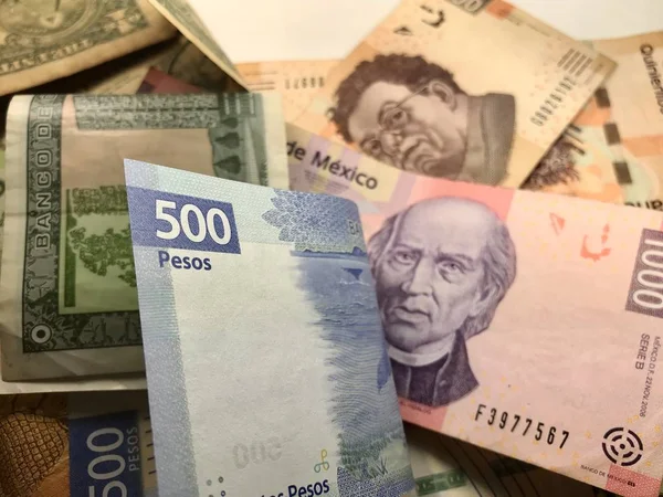 Billetes de pesos mexicanos distribuidos aleatoriamente sobre una superficie plana — Foto de Stock