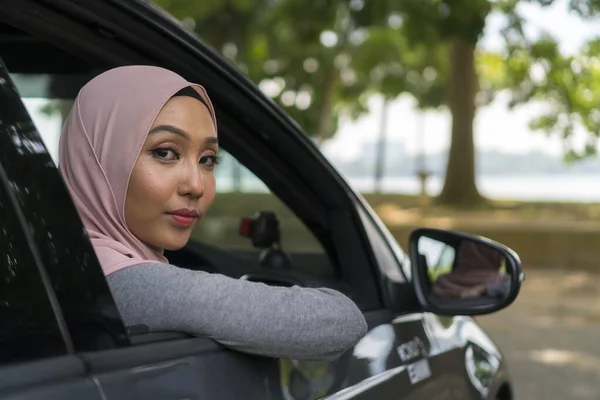 सुंदर एशियाई लड़की हिजाब पहने हुए कार खिड़कियों के माध्यम से देख — स्टॉक फ़ोटो, इमेज