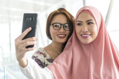 İki arkadaş tren istasyonundaki arkadaşlık konseptinde selfie çekiyorlar.