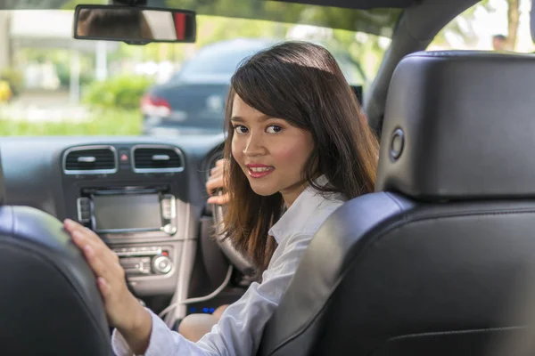 Menina asiática bonito no carro sorrindo e-saudando conceito — Fotografia de Stock
