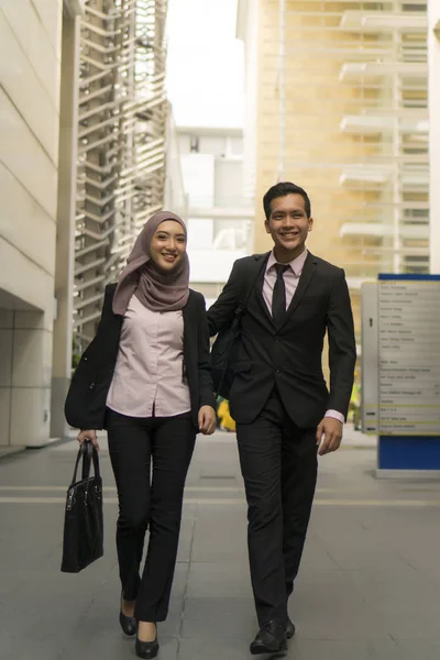 Casal Malaio vestindo terno andando no prédio de escritórios — Fotografia de Stock