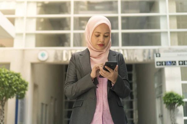 Cep telefonu kullanırken tesettürlü Asyalı İş Kadınları — Stok fotoğraf
