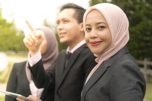 Young Asian Malay Executive at the park wearing suit