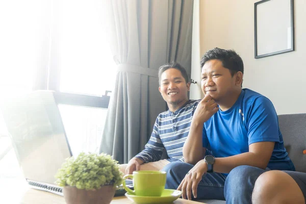 아시아인 말레이인 친구들 이 아파트에서 노트북 컴퓨터로 영화를 보고 있습니다. — 스톡 사진