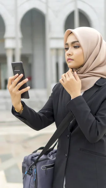 Carino asiatico malese signora a piedi a corridoio indossare vestito utilizzando telefono — Foto Stock